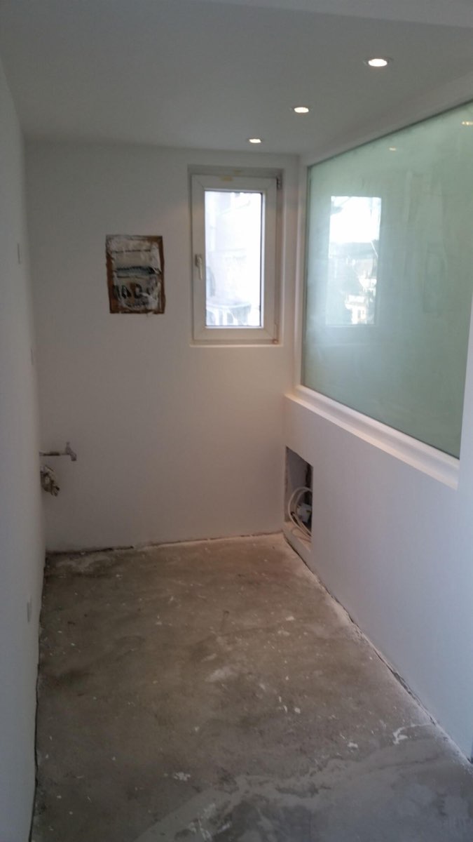 Raum mit neuem Fenster und raumhoher Glaswand, Boden noch im Rohbau